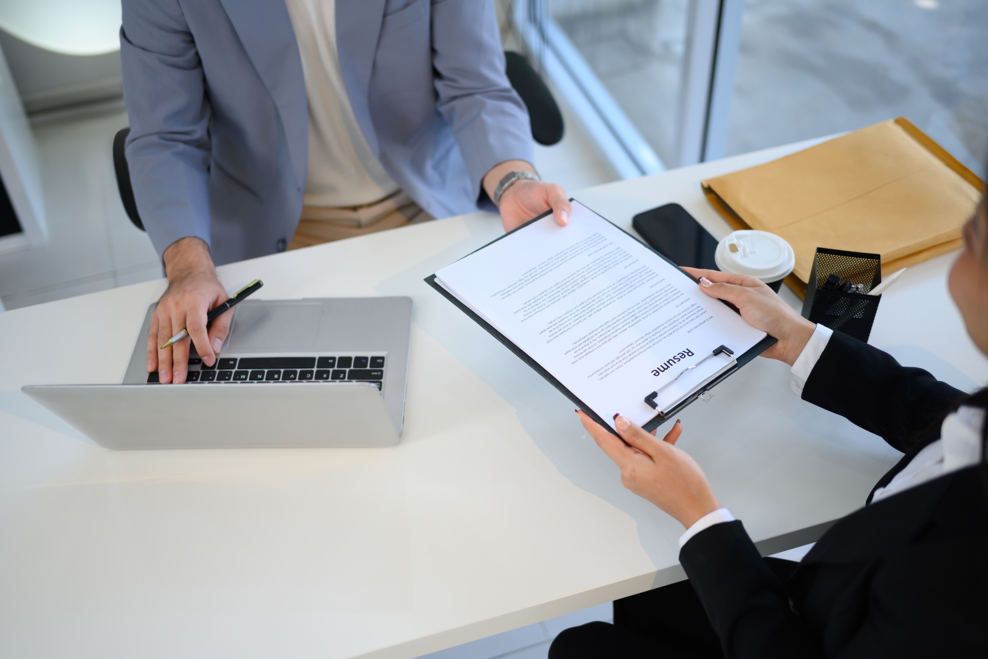 Job candidate handing over her resume during job interview